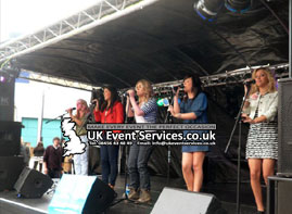 covered stage roof system for outdoor use - cherish performing on stage at recent event